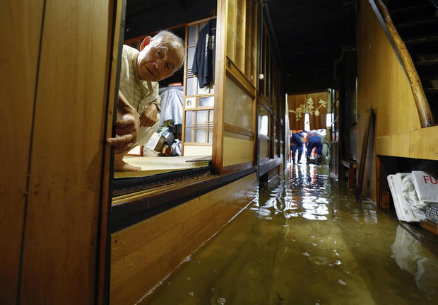 A man looks on inside his flooded house at an area affected by floods due to heavy rains caused by Typhoon Shanshan in Ogaki 