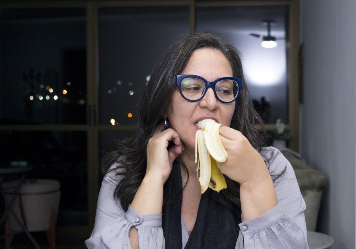 Stock image of woman eating banana.