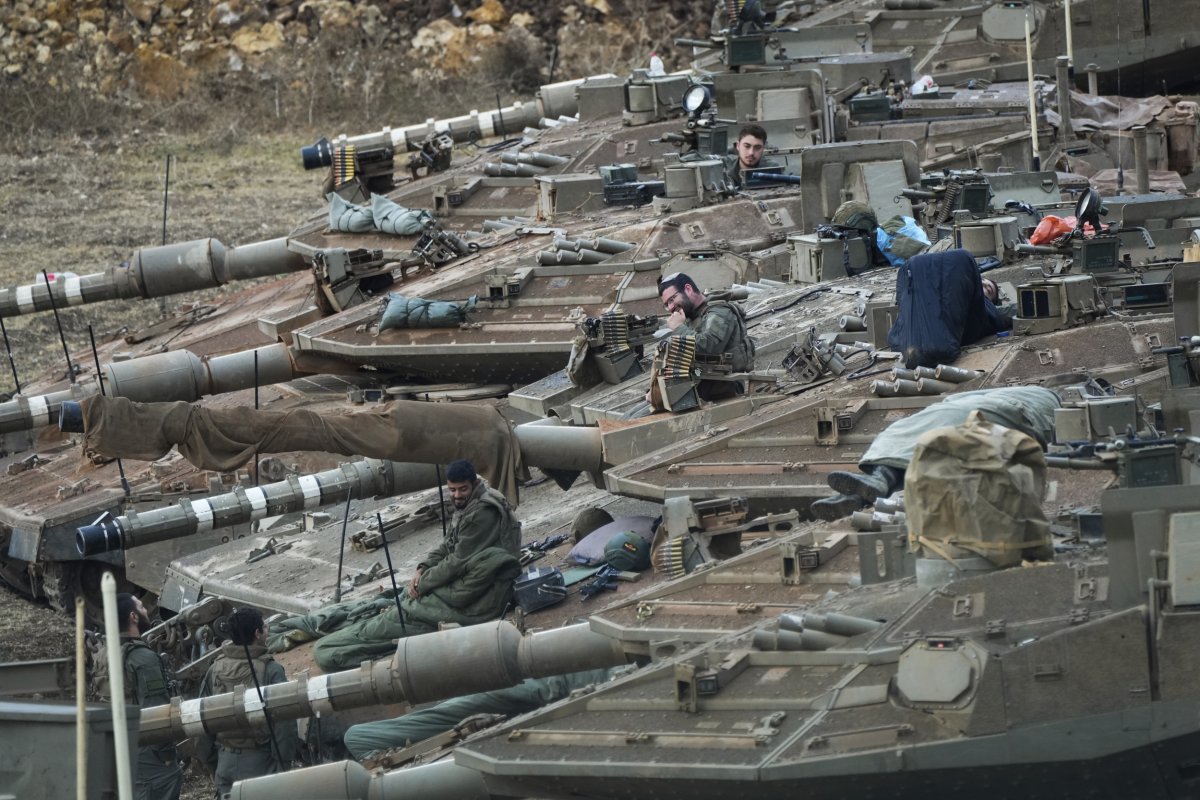 Israeli soldiers work on tanks