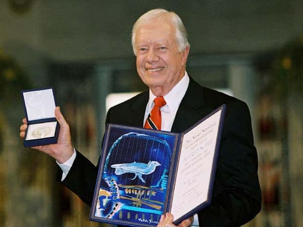 Former President Jimmy Carter holds up his Nobel Peace Prize at a ceremony in Oslo, Norway, on Dec. 10, 2002 